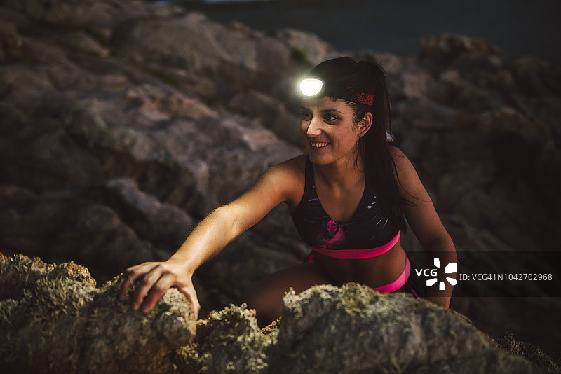 戴头灯攀岩的运动型女子图片素材