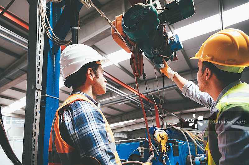 男性员工使用遥控器操作起重机的工业机械图片素材