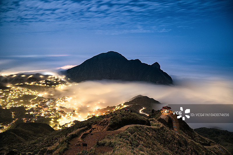 夜间山脉和城市上方的绚丽云彩景观图片素材