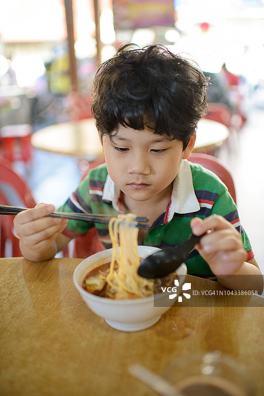 亚洲男孩品尝槟城著名福建面图片素材
