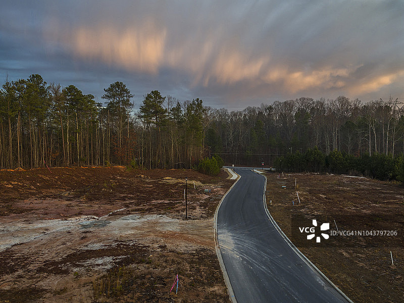 通往森林的空旷道路上空的云彩图片素材