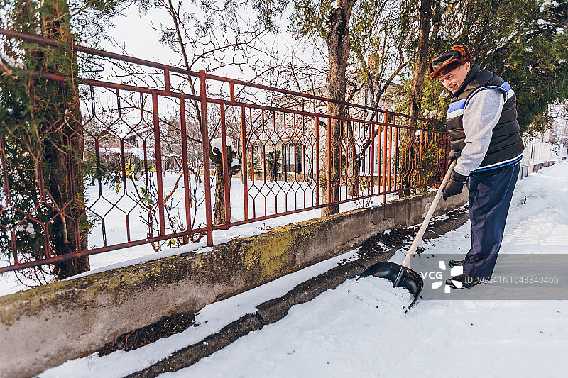 年长的男人在扫雪图片素材