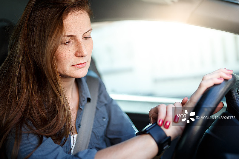 在交通堵塞中查看智能手表的商务女人图片素材