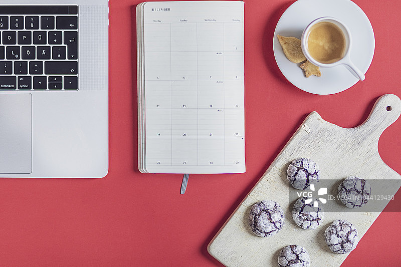 带有笔记本电脑、笔记本、咖啡杯、圣诞饼干和砧板的工作场所的高角度视图图片素材