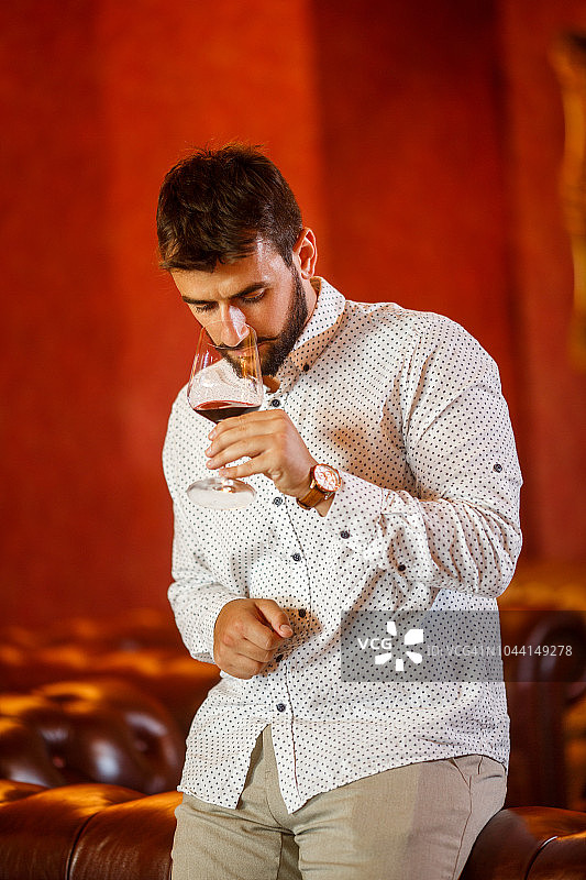 男人品味葡萄酒的香味图片素材