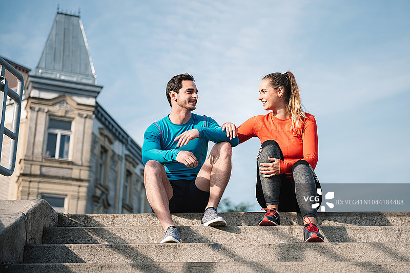 户外坐在楼梯上的运动情侣图片素材