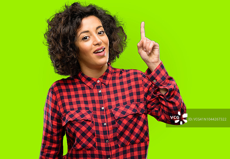 快乐的阿拉伯妇女欢呼雀跃，指向上方图片素材