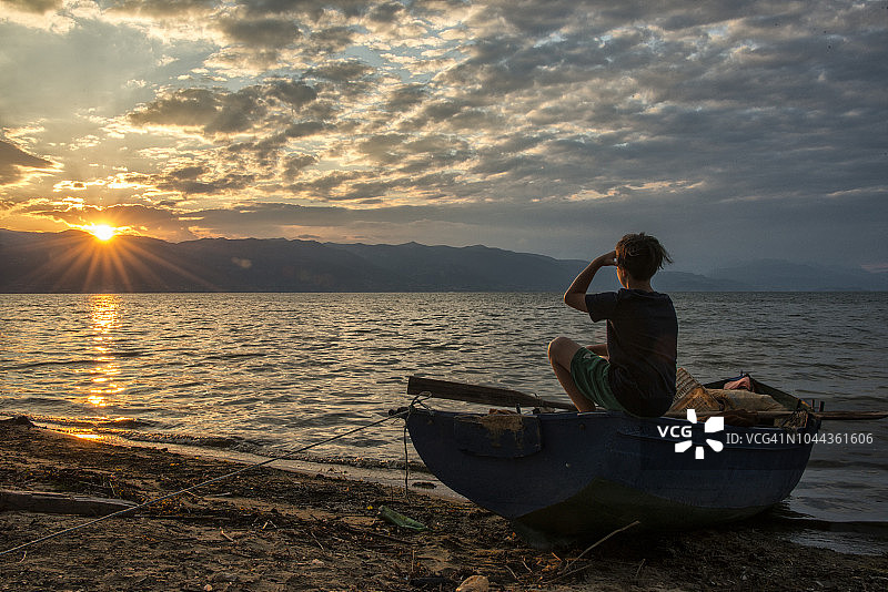 阿尔巴尼亚奥赫里德湖日落时分的男孩剪影图片素材