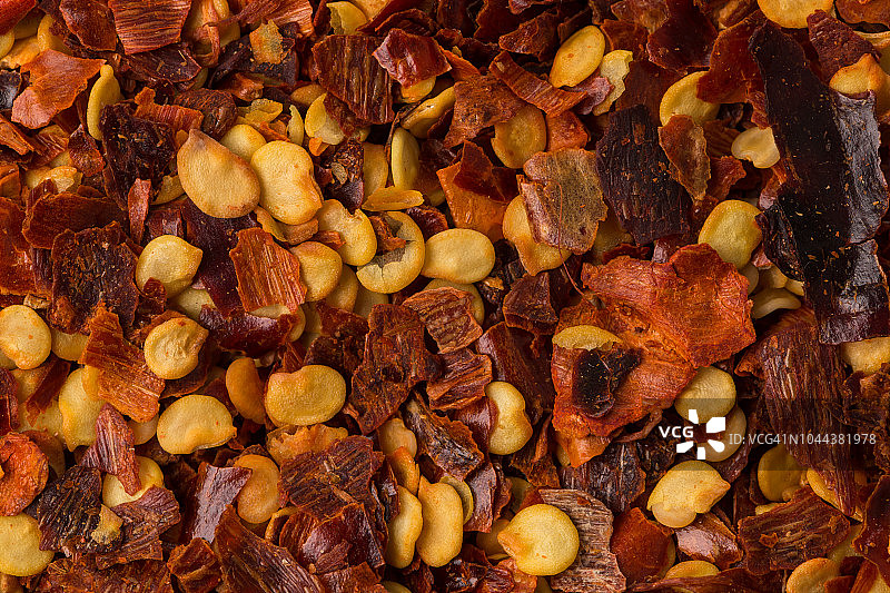 作为背景的碎红辣椒、干辣椒片和种子堆图片素材