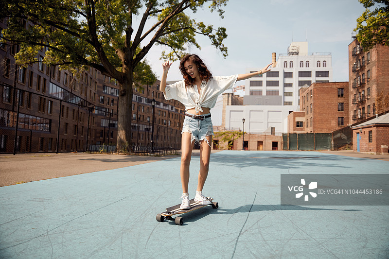 在城市里玩滑板的年轻女子图片素材