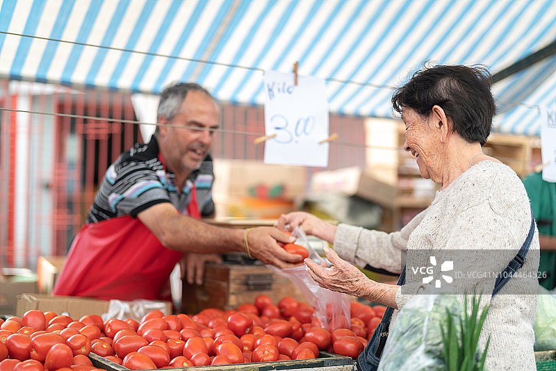 农贸市场上的年长日本女性顾客和销售员图片素材