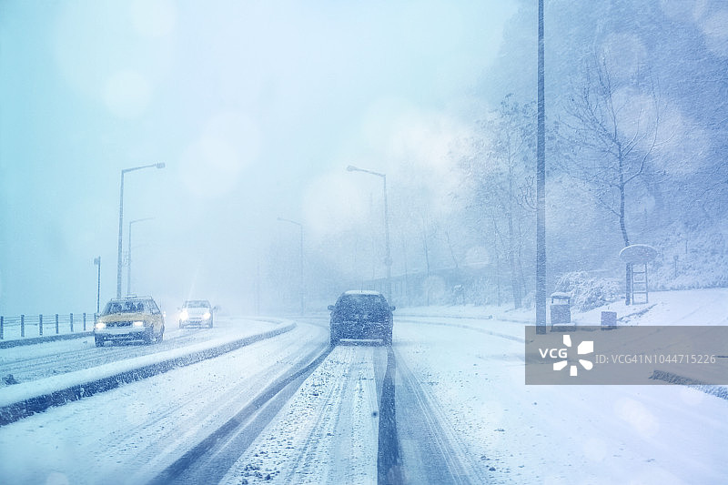 暴风雪中在雪地行驶的汽车图片素材