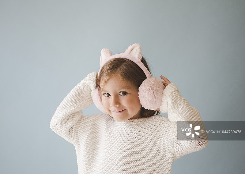 戴着粉色耳罩和猫耳的女孩图片素材