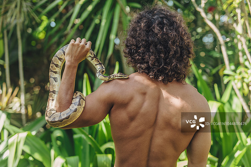 在森林里手持蛇的男人图片素材