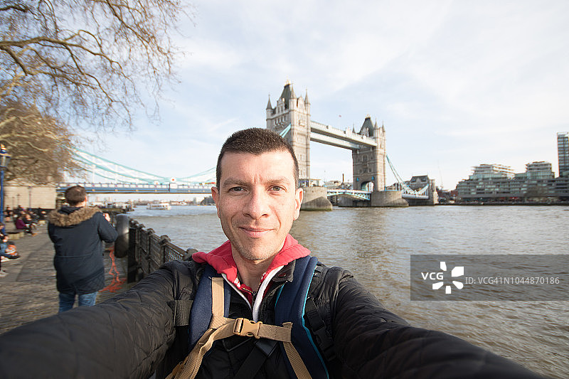 在英国伦敦塔桥和泰晤士河前，男子自拍图片素材