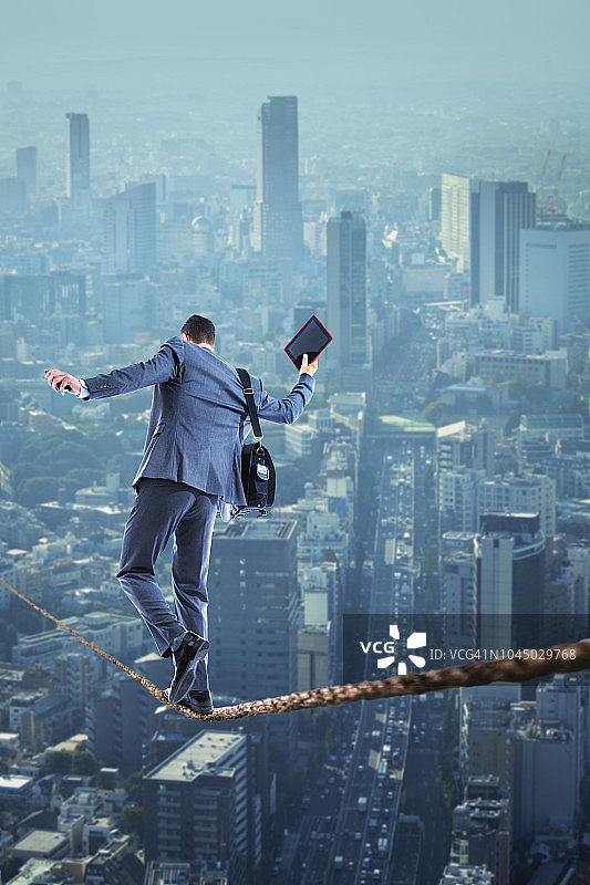 在城市上空走钢丝的商人图片素材
