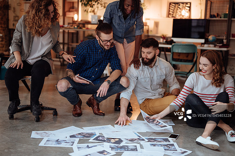 坐在地板上看照片的人群图片素材