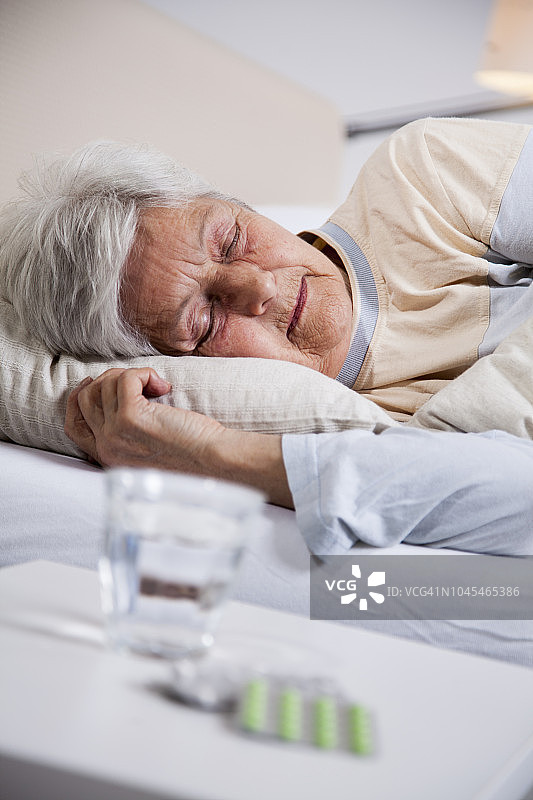 年长妇女床边的药丸图片素材