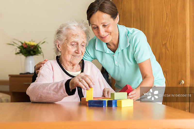 居家护理员和老年妇女玩积木图片素材