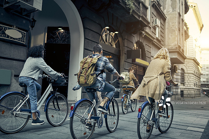 朋友们在城市里骑共享单车图片素材