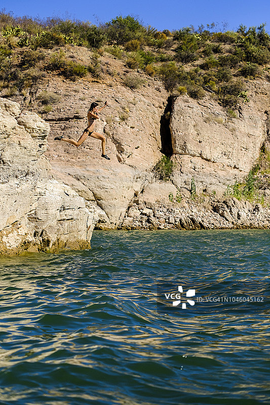 女孩从悬崖跳入亚利桑那州罗斯福湖图片素材