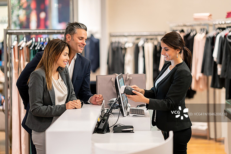 购物情侣在收银台刷卡支付图片素材