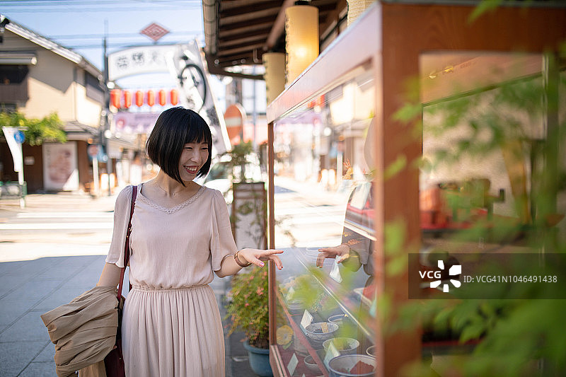 亚洲游客在日式餐厅橱窗前观看图片素材