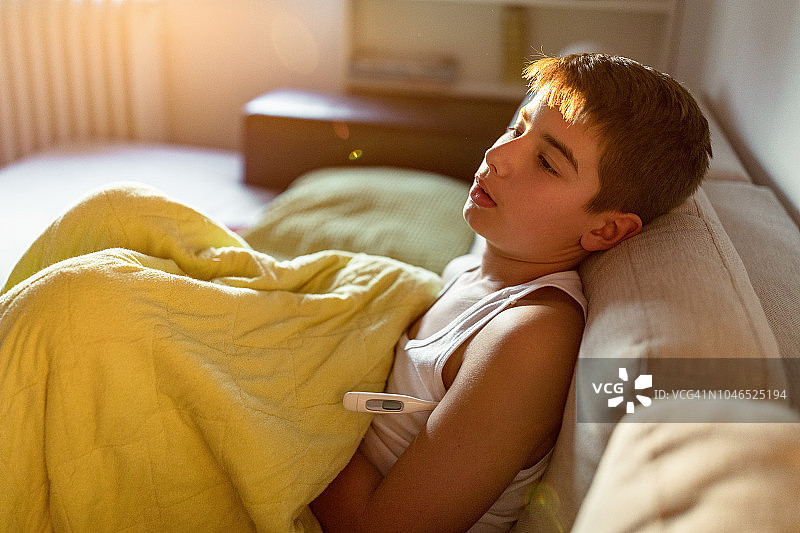 在床上量体温的男孩图片素材