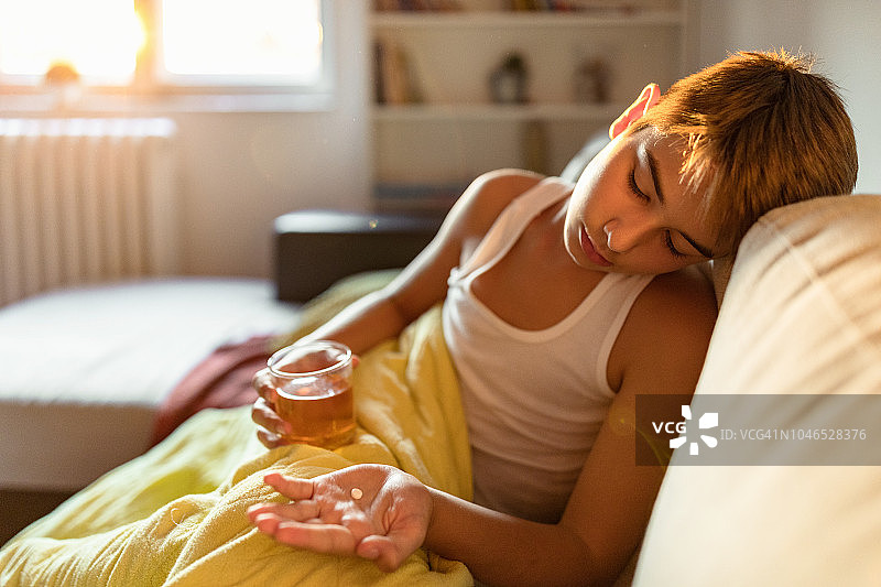 发烧的男孩坐在床上图片素材