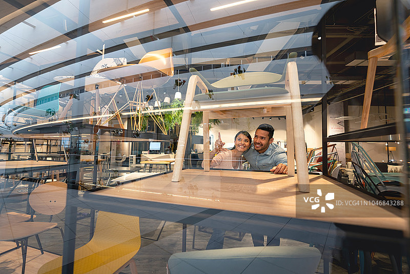 快乐的情侣在家具店购物图片素材