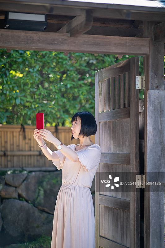 亚洲游客在日本花园前自拍图片素材