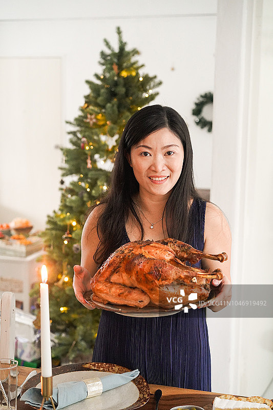 年轻的亚洲母亲准备圣诞火鸡晚餐图片素材