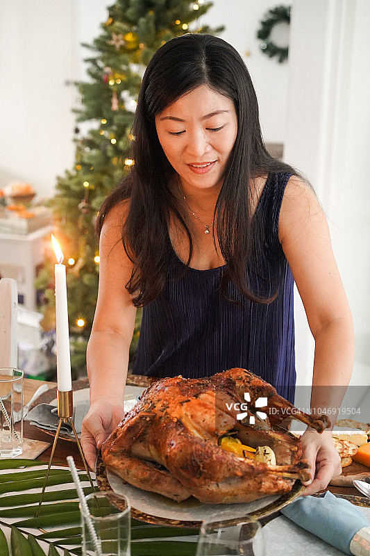 年轻的亚洲母亲准备圣诞火鸡晚餐图片素材