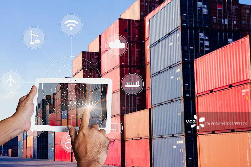 商人手持平板电脑触摸屏，显示全球合作伙伴物流进出口连接图片素材