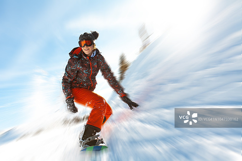 在滑雪道上玩耍的女子单板滑雪者图片素材