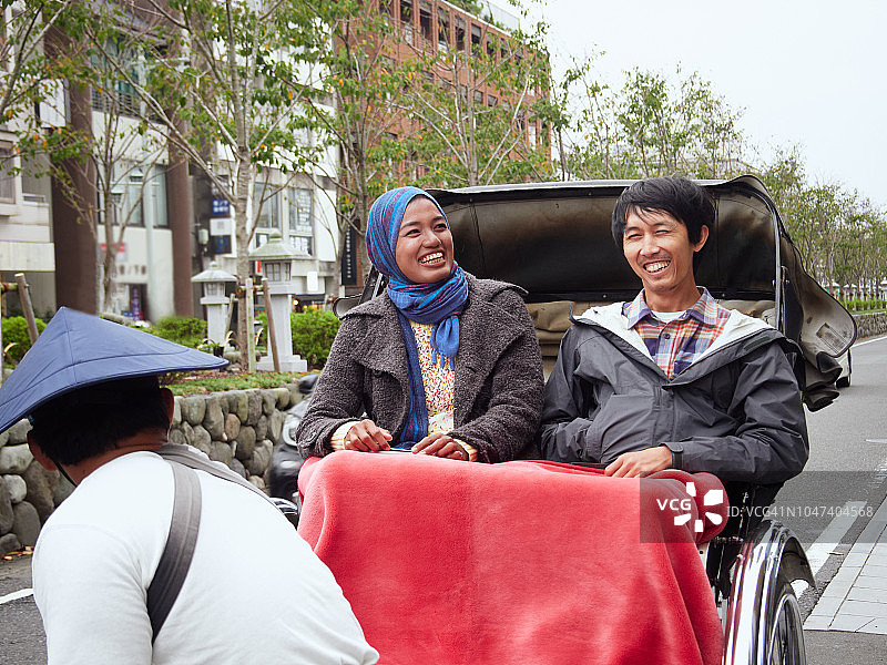 在东南亚乘坐人力车的情侣图片素材
