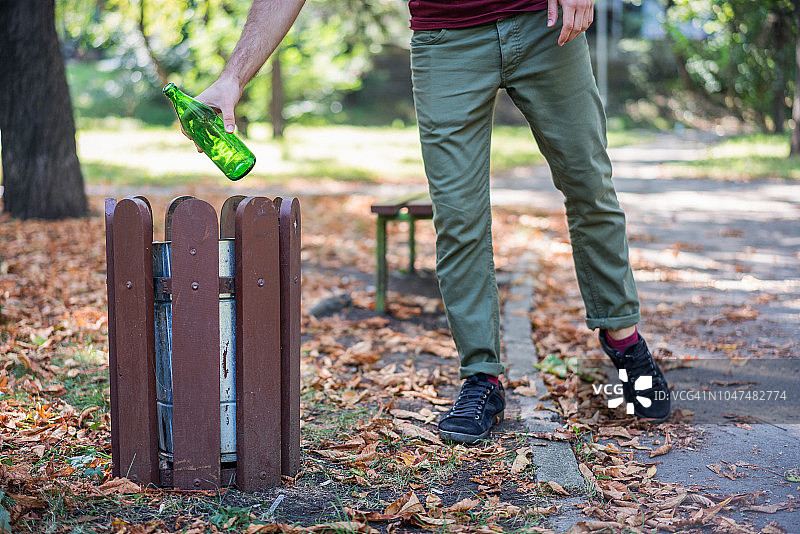 男人扔玻璃瓶到垃圾桶图片素材
