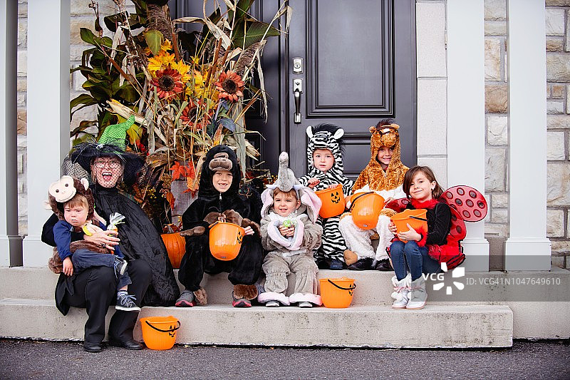患有唐氏综合征的小男孩和他的朋友们穿着万圣节服装图片素材