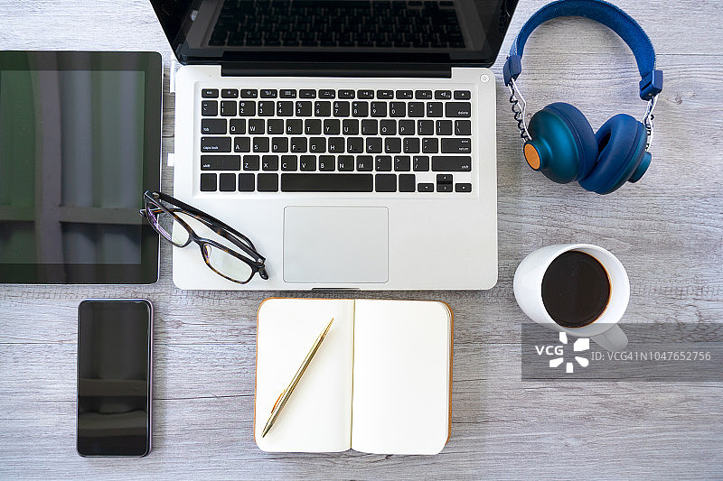 木桌背景上的混合办公用品和小工具。俯视图图片素材