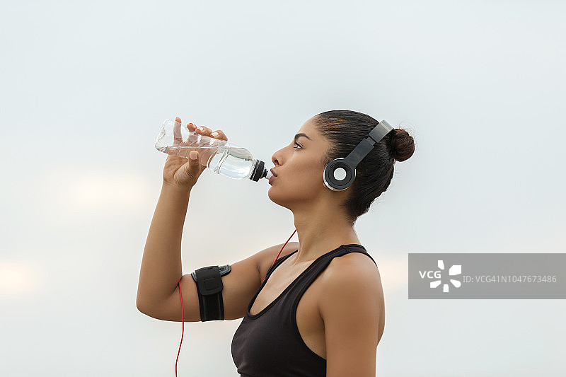 户外跑步后补充水分的女人图片素材