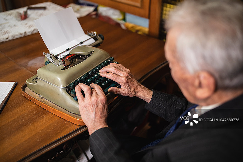 使用打字机的年长男人图片素材