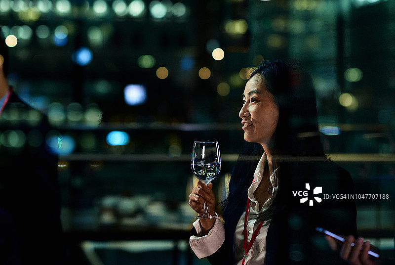 侧面拍摄：中国女商人正在品酒图片素材