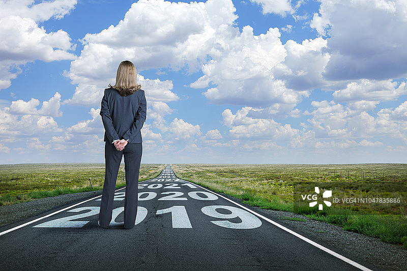 女商人站在画有年份的长路上图片素材