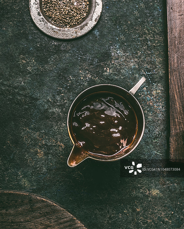 复古酱汁船中的深色酱汁，深色复古背景图片素材