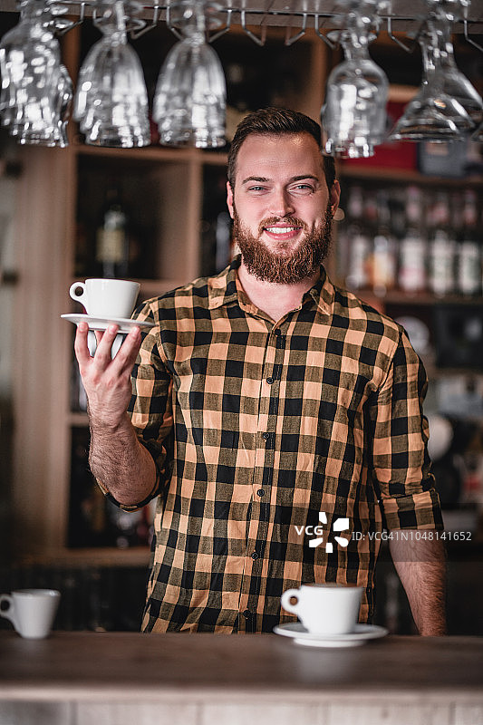 摆姿势的英俊男咖啡师和完美的意式浓缩咖啡图片素材