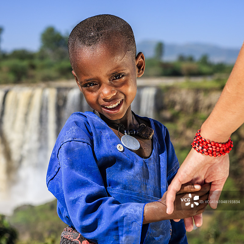 白人女性牵着非洲儿童的手图片素材