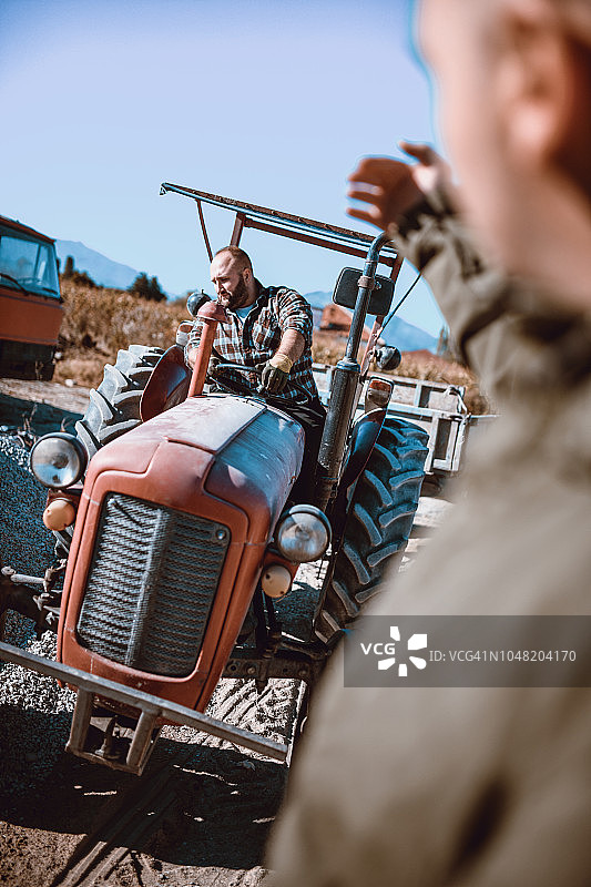 男人帮助拖拉机司机指路图片素材