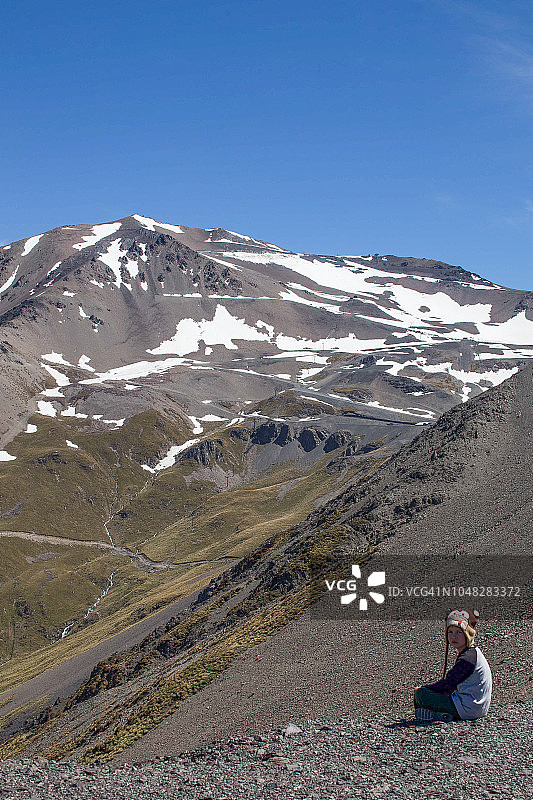 春季山地滑雪场，前景中坐着一个小男孩图片素材