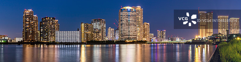 东京隅田川的城市景观全景，灯火通明的摩天大楼和建筑物图片素材
