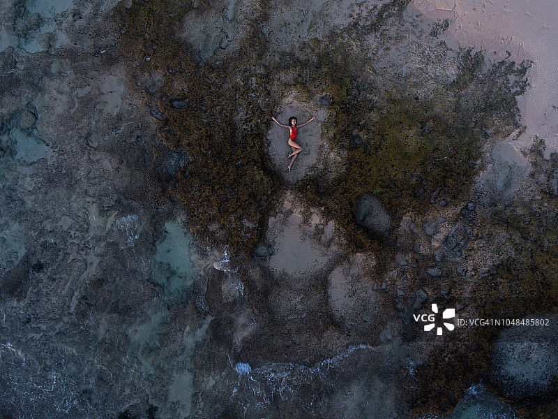 在巴厘岛天然无边泳池中游泳的女人图片素材